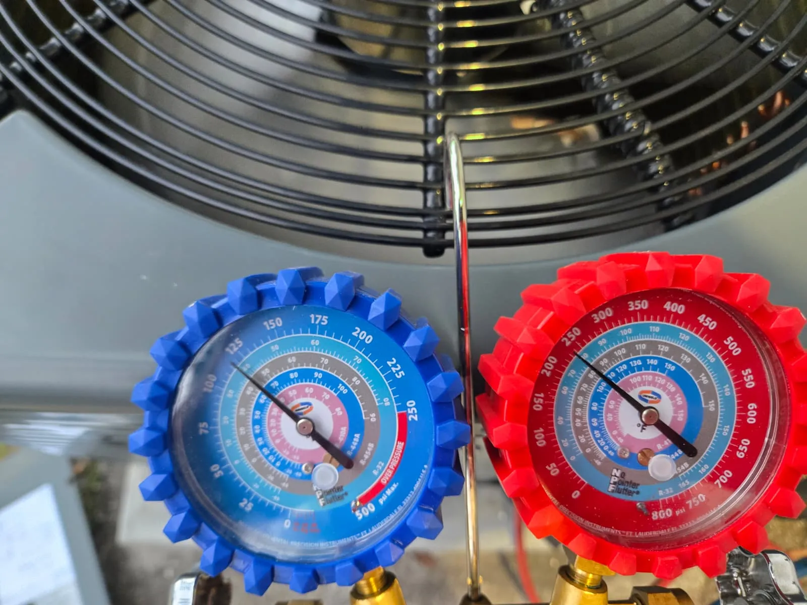 Manómetros profesionales midiendo presión de refrigerante en una unidad de aire acondicionado