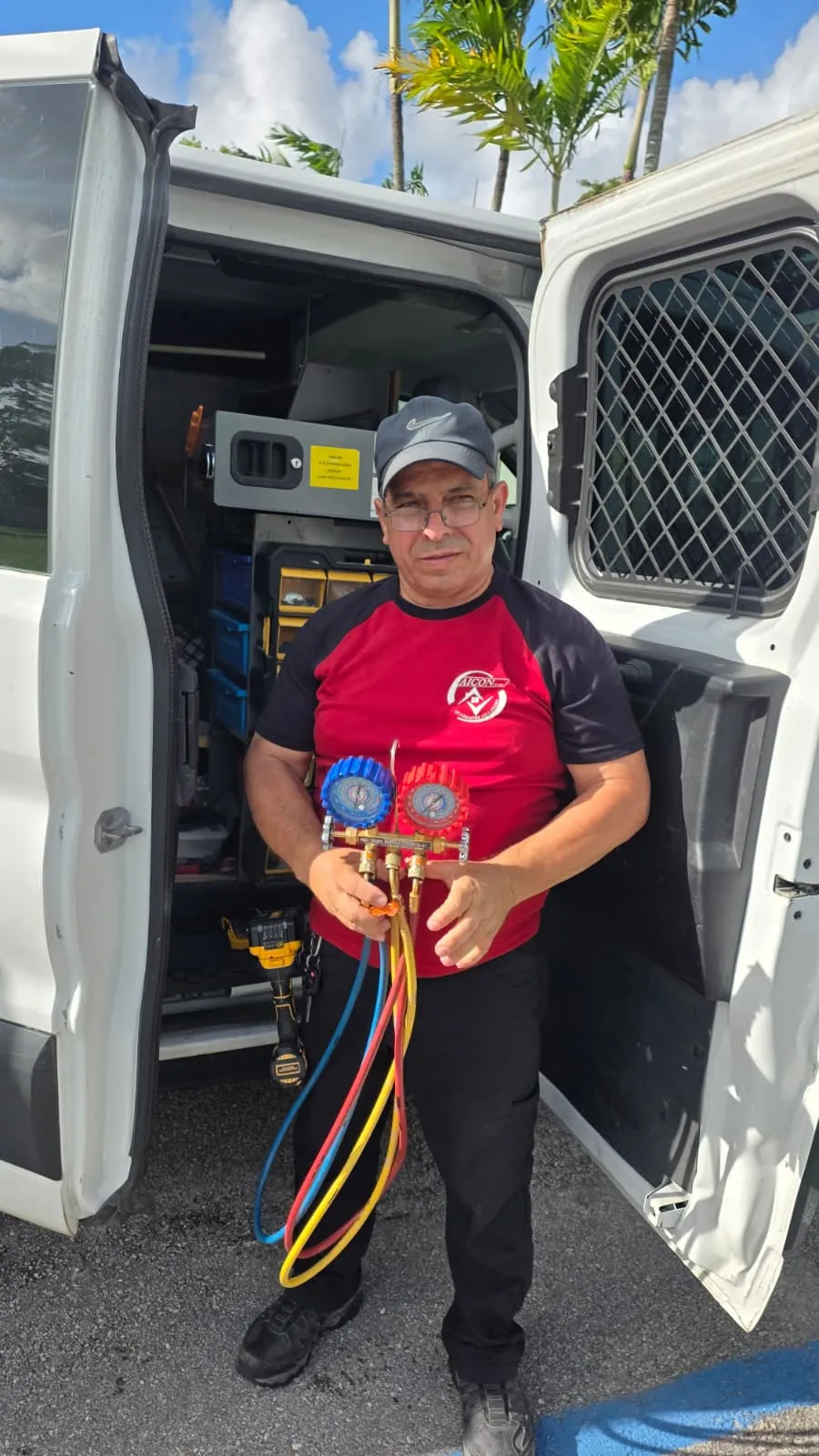 Juan Carlos Santana con manómetros profesionales frente a su van Aicon Corp